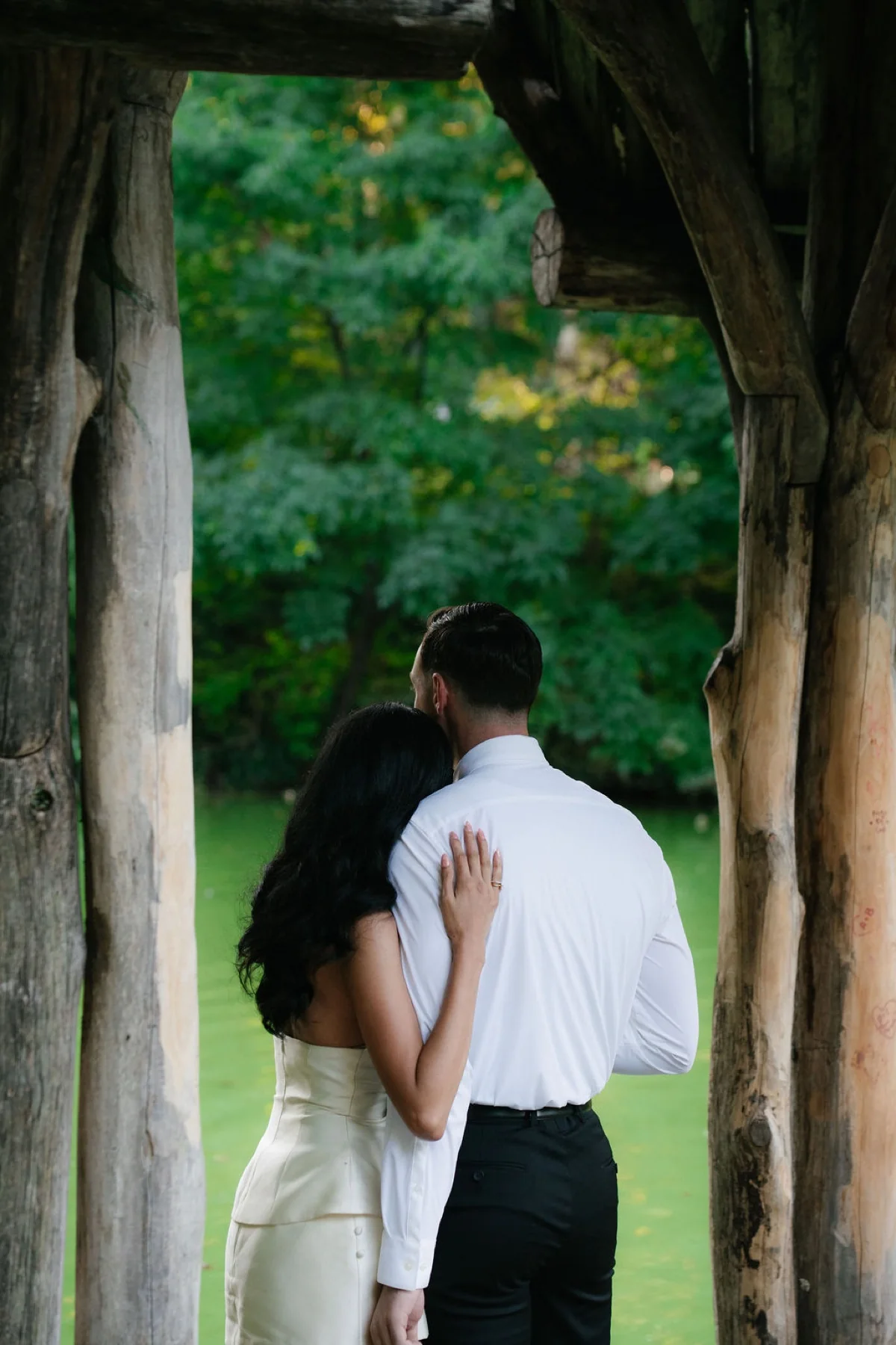 An engaged couple embracing after the proposal beside the pond