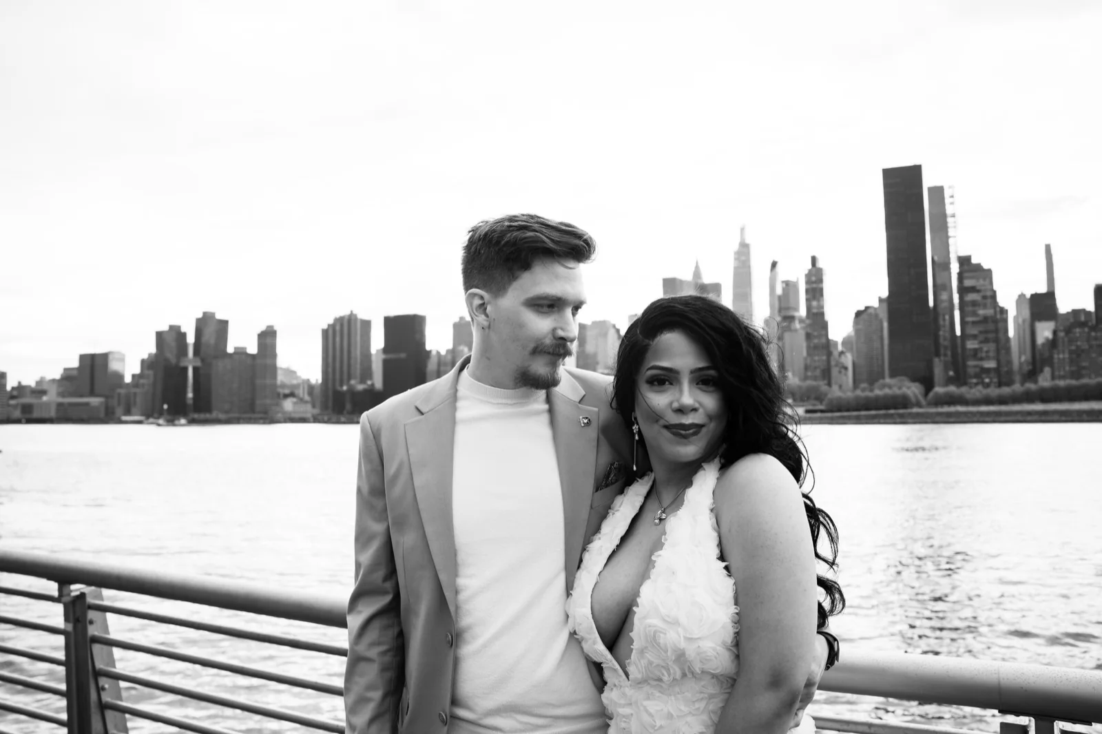 A couple standing together with the Manhattan skyline behind them