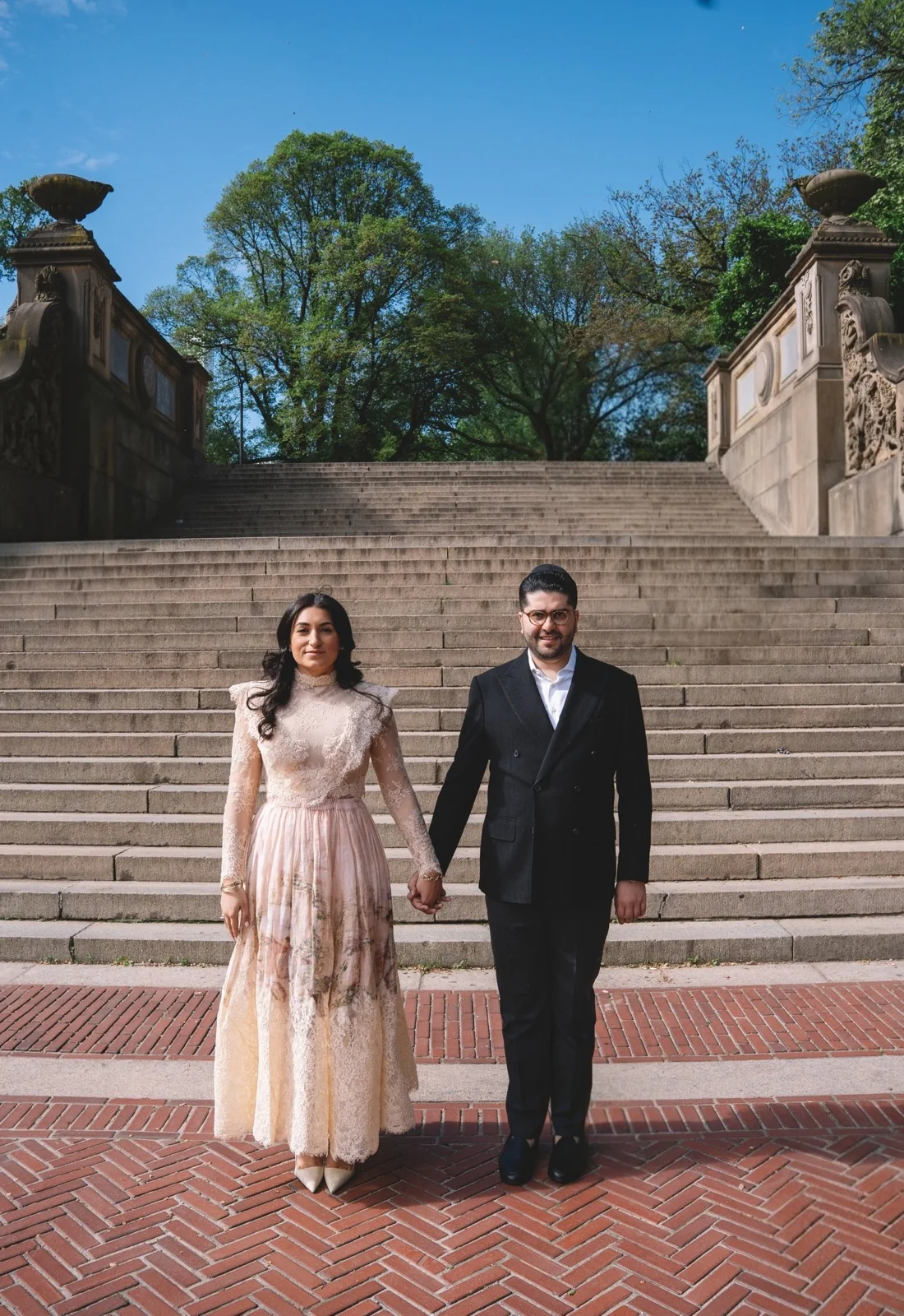 A couple holding hands on the steps of Bethesda Terrace