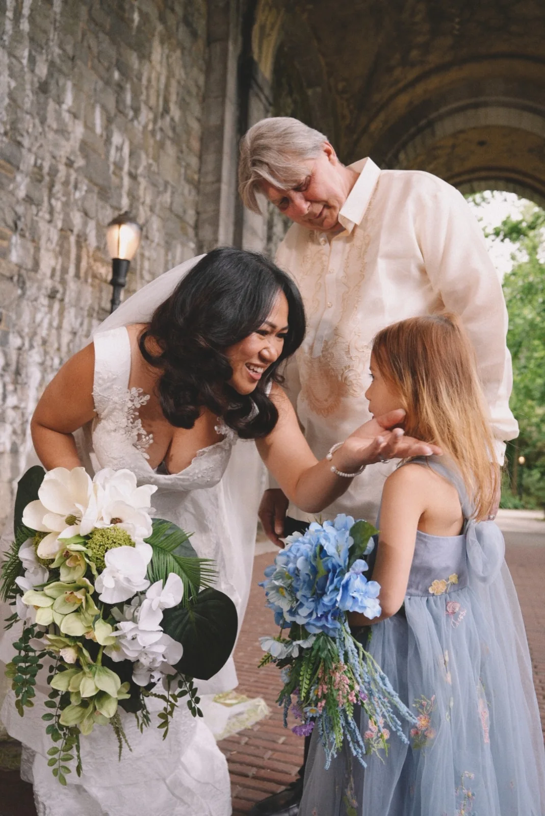 Newlyweds smiling with a young wedding guest